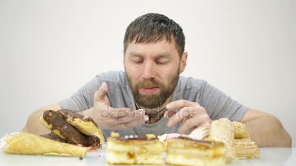 El barbudo devora un pastel. comida dañina pero deliciosa — Vídeos de Stock