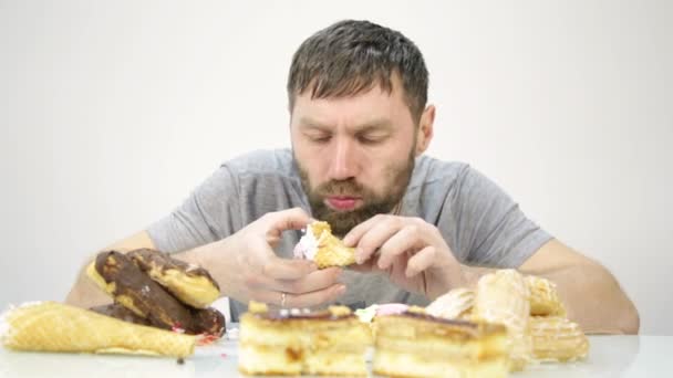 O homem barbudo devora um bolo. alimentos nocivos, mas deliciosos — Vídeo de Stock