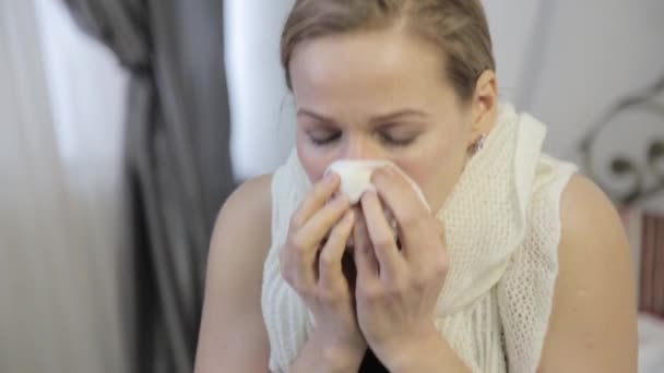 Sick woman sneezes loudly and wipes his nose — Stock Video