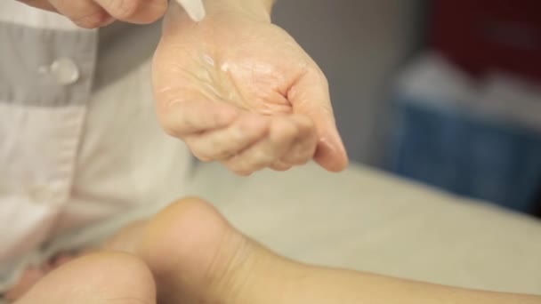 Массаж женских ног с увлажняющим лосьоном — стоковое видео