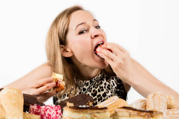 Ung kvinna äta cupcakes med glädje efter en diet — Stockfoto