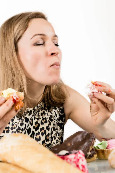 Mladá žena jíst cupcakes s radostí po dietě — Stock fotografie