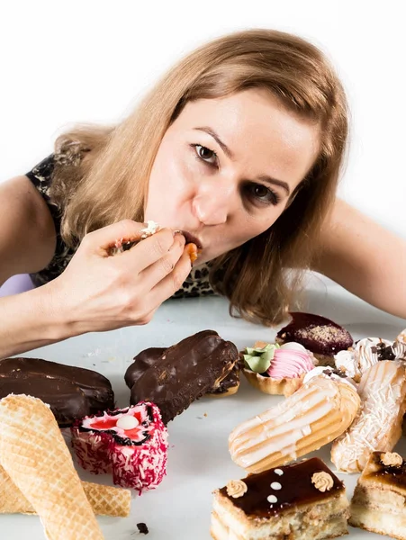 Mujer joven comiendo magdalenas con placer después de una dieta —  Fotos de Stock