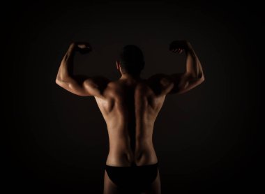 Güçlü kas adam gövde pozlar siyah arka plan üzerine