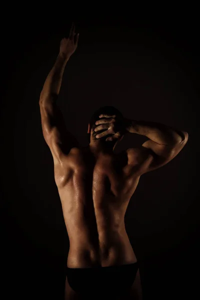 Forte homem muscular torso poses no fundo preto Fotografia De Stock
