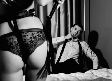 yakışıklı adam önünde bir kırbaç konumu olan iç çamaşırı, seksi kadının kalça. BDSM kavramı