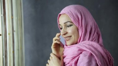 pencerenin önünde telefonda konuşmak güzel Müslüman kadın