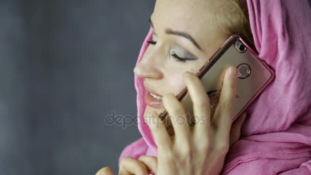 Beautiful muslim woman in pink hijab talking on cell phone — Stock Video