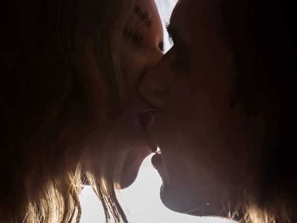 Primo piano di giovane coppia in appassionato baciare su sfondo luminoso — Foto Stock