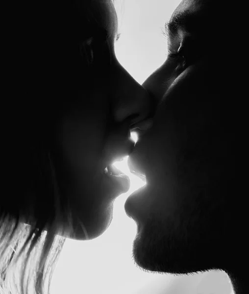 Primer plano de pareja joven besándose apasionadamente sobre un fondo brillante — Foto de Stock
