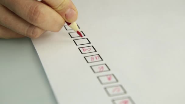 close-up hand of student filling out answer sheets with red pencil