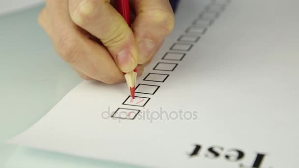 빨간 연필로 대답 시트 작성 하는 학생의 근접 손 — 비디오