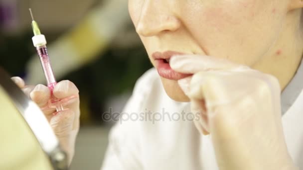 Инъекции губ пластическая хирургия. Косметик делает себе увеличение губ — стоковое видео