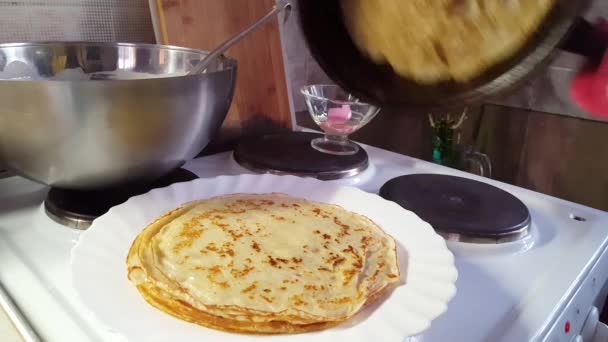 Τηγανίζουμε τηγανίτες σε ένα skillet ω μια κουζίνα στο σπίτι. οικιακή ρουτίνα — Αρχείο Βίντεο