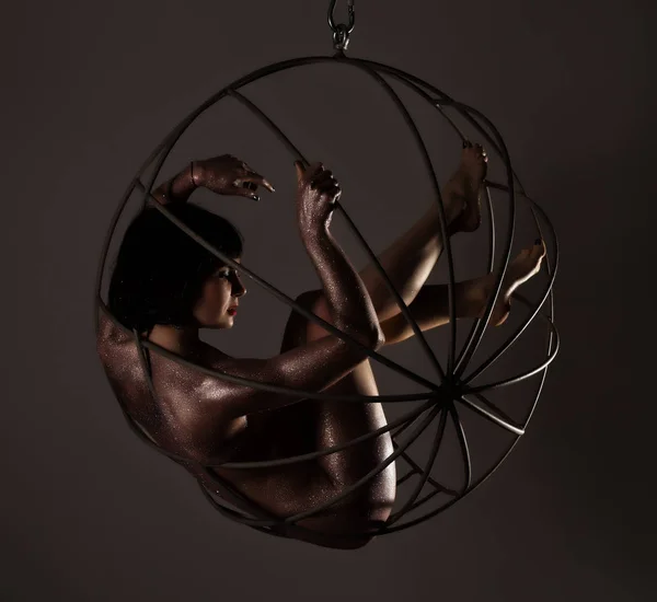 bir deri bir yuvarlak metal salıncak üzerinde güzel çıplak kız mor pul ile vücut sanatı
