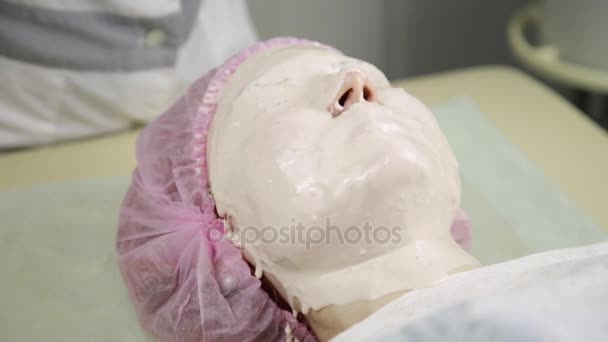 Estetista applicare la maschera facciale su un viso donna, pulizia trattamento della pelle — Video Stock