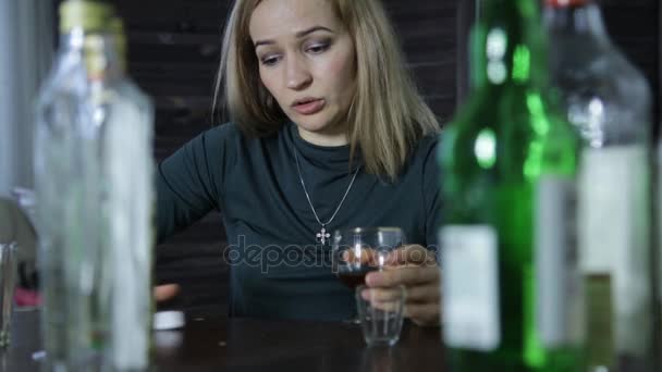 Lonely sad woman drinks alcohol, lot of empty bottles around her — Stock Video