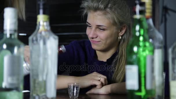 Одинокая грустная женщина пьет алкоголь в баре, вокруг неё много пустых бутылок — стоковое видео