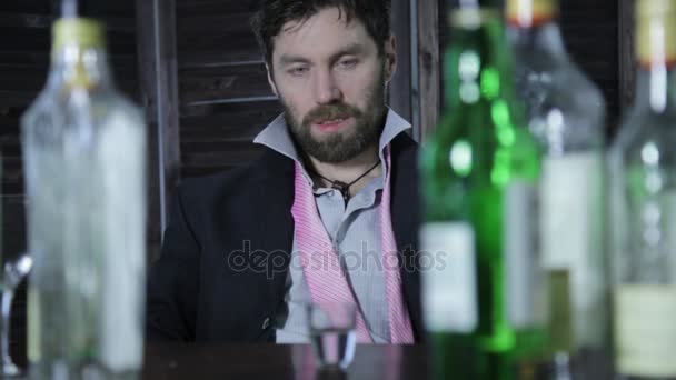 Μοναχικός άνθρωπος λυπημένος αλκοολούχων ποτών, πολλά μπουκάλια γύρω από τον — Αρχείο Βίντεο