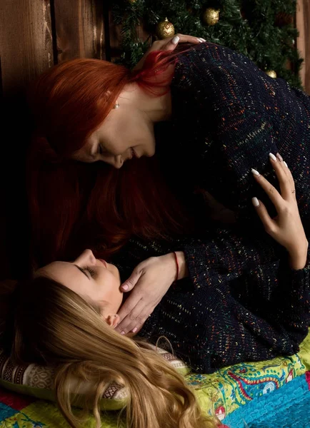 Duas lésbicas bonitas namoradas beijando e abraçando em uma atmosfera acolhedora — Fotografia de Stock