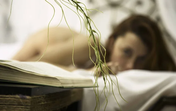 Mujer sexy joven en ropa interior blanca se relaja en una cama en la habitación de hotel —  Fotos de Stock