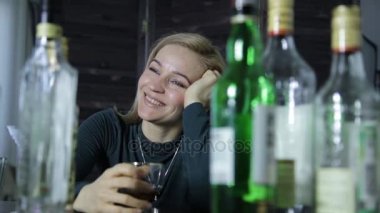 Yalnız genç kadın içecekler, alkol bar ve kendi kendine konuşuyor