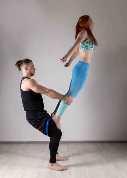 Ragazzo e giovane donna che fanno esercizi di forza in assani di yoga. Concetto di Acroyoga — Foto Stock