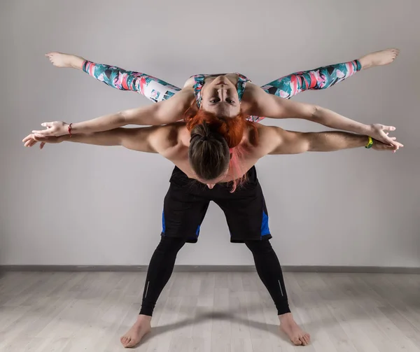 Guy a mladá žena, která dělá síla cvičení jógy assanes. Acroyoga koncept — Stock fotografie