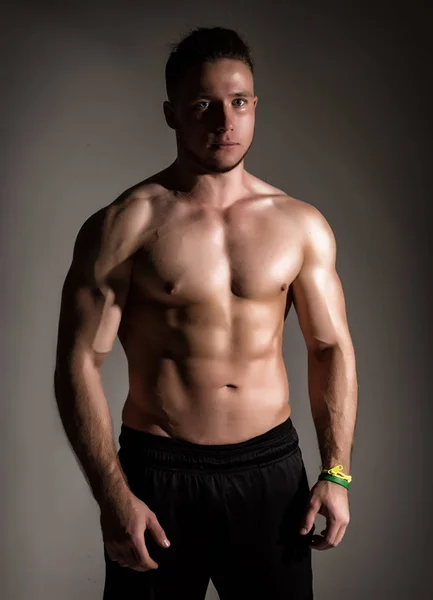 Silná sportovní svalnatý muž na tmavém pozadí — Stock fotografie