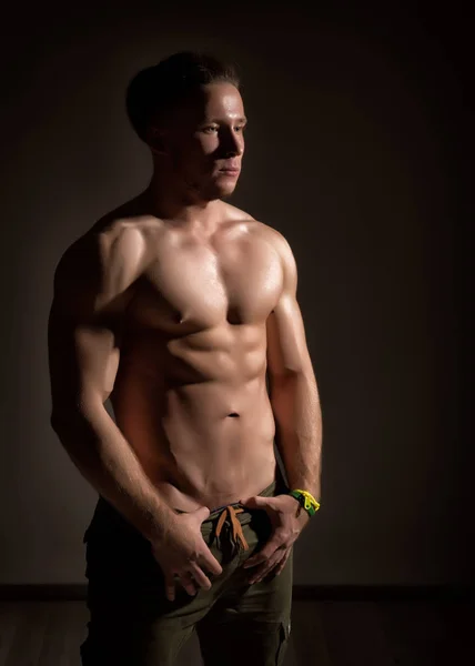 Starker athletischer muskulöser Mann mit dunklem Hintergrund — Stockfoto