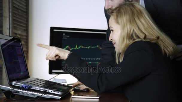 同事讨论股票交易所的汇率变动。在笔记本电脑上观看货币兑换图 — 图库视频影像