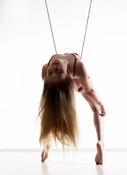 Chica delgada perfecta con una cuerda posando sobre un fondo claro. Sexy cuerpo atlético — Foto de Stock