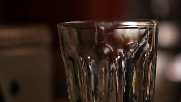 Production of strong drinks, drops of alcohol drip into a glass — Stock Video