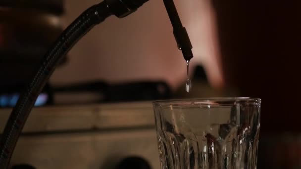 Producción de bebidas fuertes, gotas de alcohol gotean en un vaso — Vídeo de stock