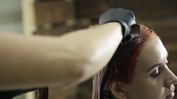 Mulher em um salão de beleza recebe coloração de cabelo. cor rosa para cliente feminino — Vídeo de Stock