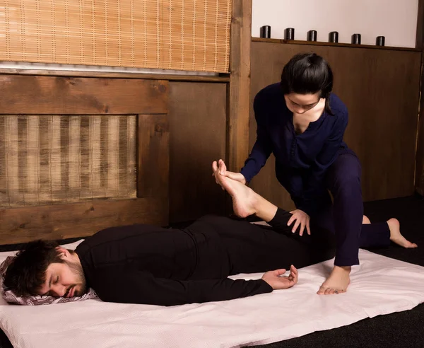 Masaje de pies en el estudio tailandés. Terapeuta profesional dando masaje tailandés tradicional — Foto de Stock