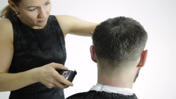 Peluquería femenina moldeando para hombre corte de pelo utiliza tijeras en un salón de belleza — Vídeo de stock