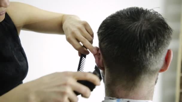 Female hairdresser shaping mens hair cutting uses scissors in a beauty saloon — Stock Video