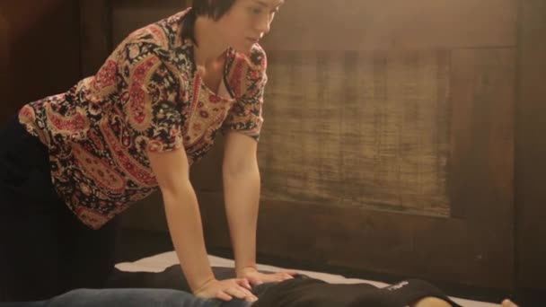 Тайский массаж ног в спа-салоне. Профессиональный массажист, выполняющий традиционный тайский массаж для клиентки — стоковое видео