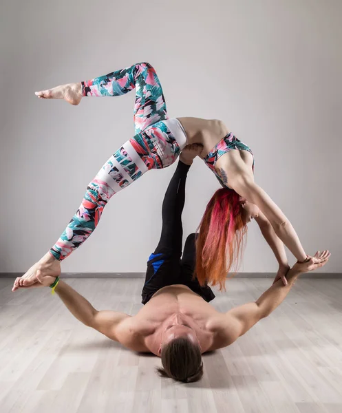 スポーツの男性と女性の暗い部屋で acroyoga の演習を行う — ストック写真