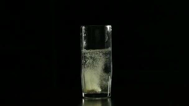 Pastillas efervescentes de primer plano en vaso de agua, aspirina para una vida sana. sobre un fondo oscuro — Vídeos de Stock