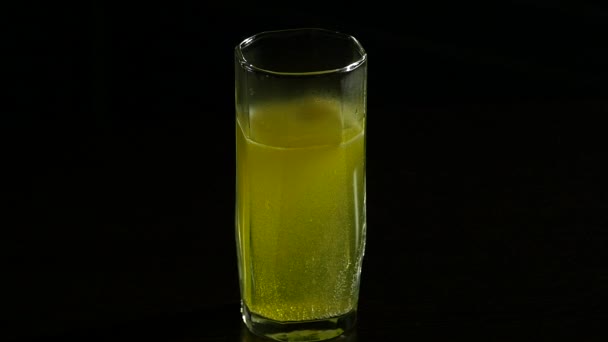 Γκρο πλαν αναβράζον δισκίο σε ποτήρι νερό, ασπιρίνη για μια υγιή ζωή. σε σκούρο φόντο — Αρχείο Βίντεο