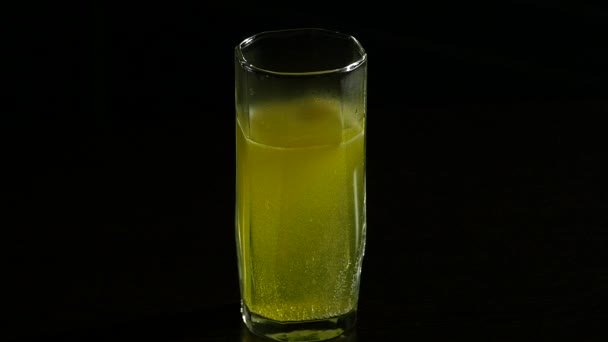 Close-up effervescent tablet in glass of water, aspirin for a healthy life. on a dark background — Stock Video