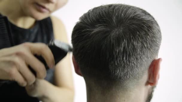 Стрижка в перукарні. перукар використовує ножиці для різання чоловіка. Жіночий перукар у формі чоловічого стрижки волосся використовує ножиці — стокове відео
