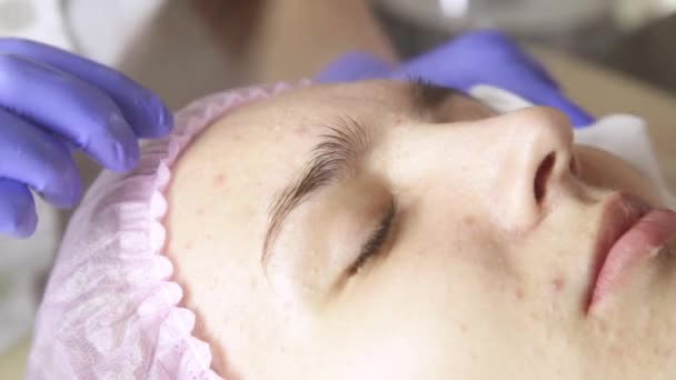 Женщина проходит санаторное лечение. Массажистка уборщица лицо с ватными тампонами в спа — стоковое видео