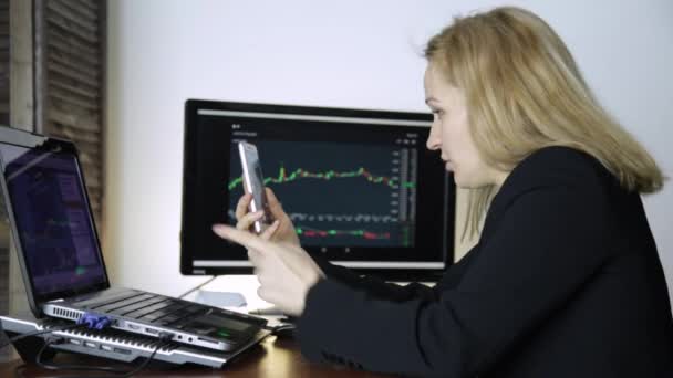 Female trader advises client on video communication for work on a crypto stock exchange. watching currency exchange chart at laptop — Stock Video