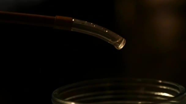 Produzione di bevande forti, gocce di alcool gocciolano in un bicchiere — Video Stock