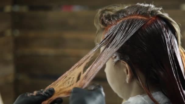 Parrucchiere rendendo la colorazione dei capelli per giovane donna. bellezza, acconciatura e concetto di persone — Video Stock