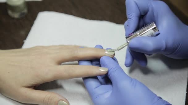 Mulheres mãos enquanto pintando suas unhas com polonês vermelho no salão de beleza — Vídeo de Stock