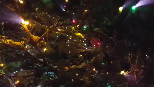 Árvore de Natal brilha com luzes coloridas. À espera do Natal no escuro — Vídeo de Stock